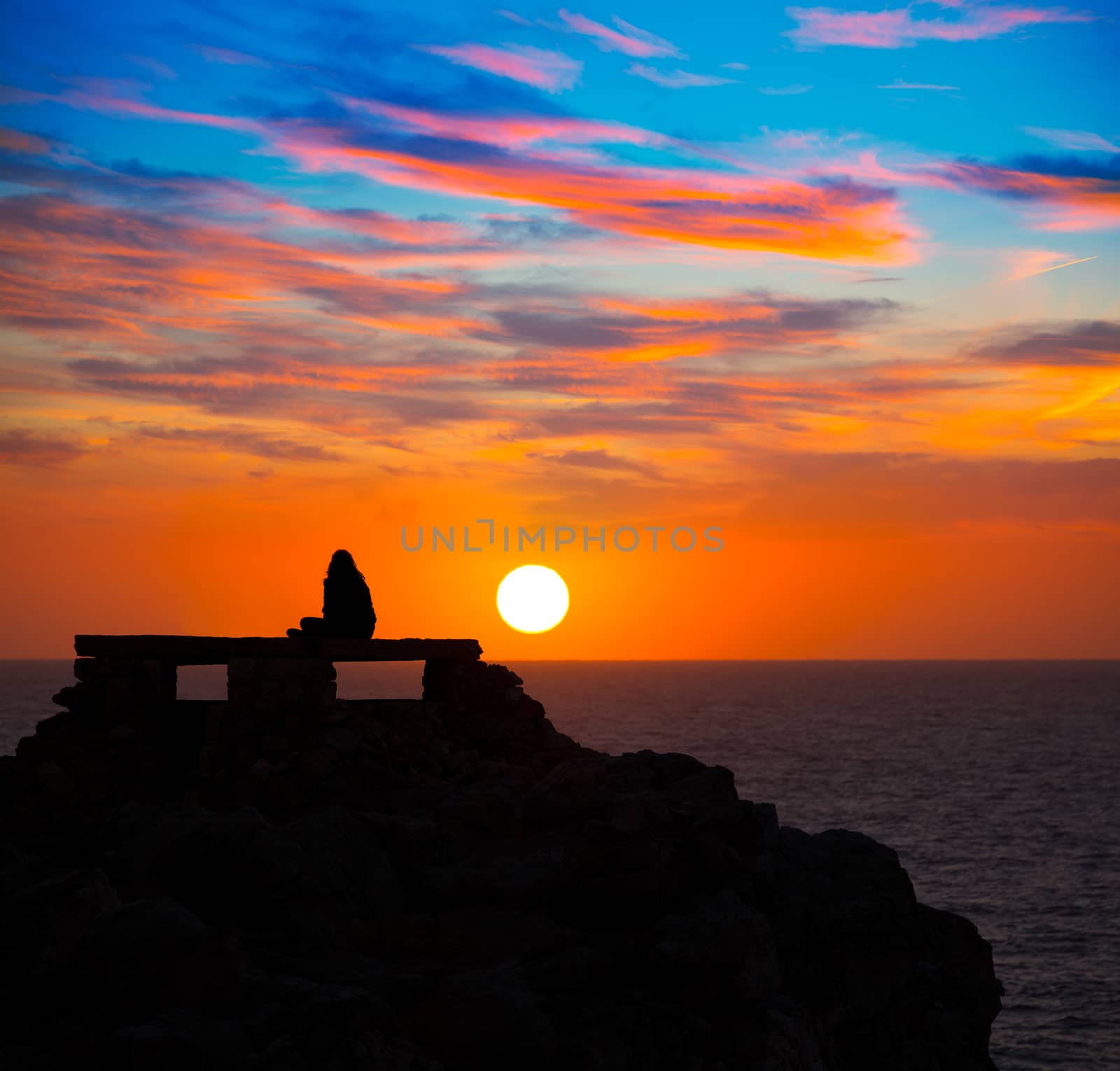 Ciutadella Menorca at Punta Nati orange sunset with girl backlight