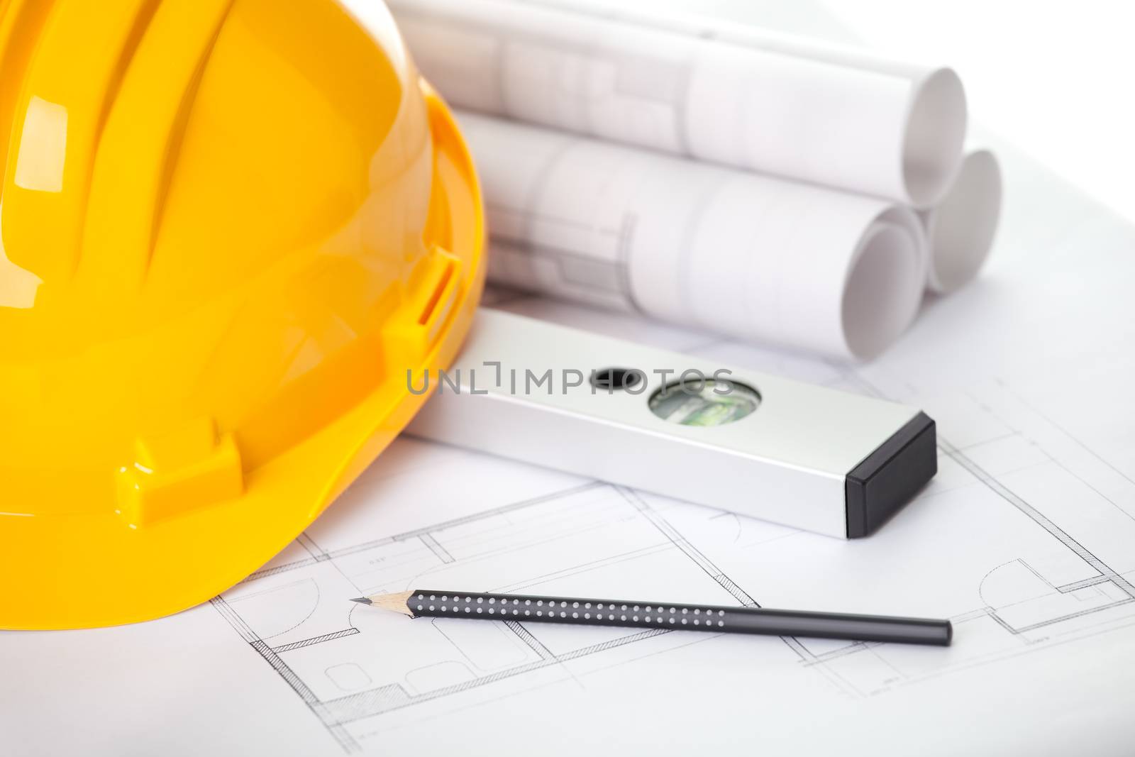 Image of yellow construction helmet with measuring level and site plan