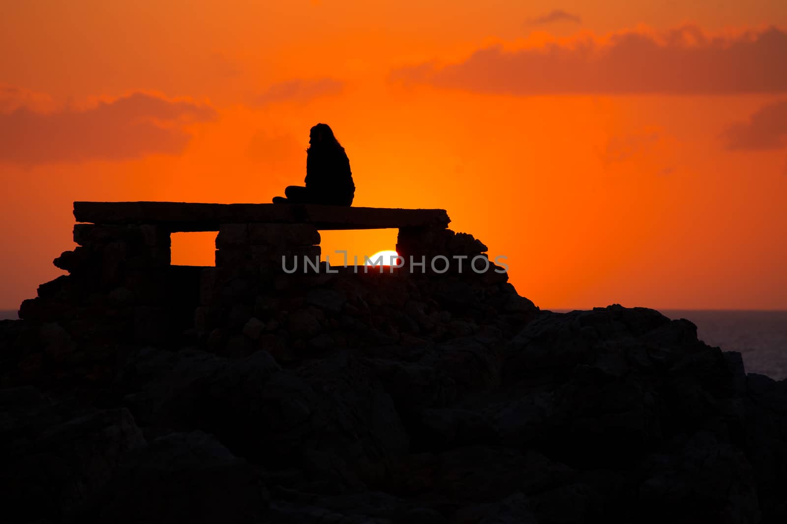 Ciutadella Menorca at Punta Nati orange sunset with girl backlight