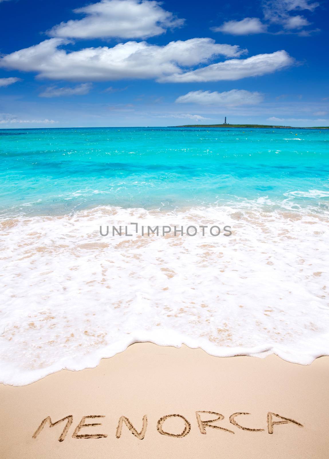 Menorca word written on sand of mediterranean beach by lunamarina