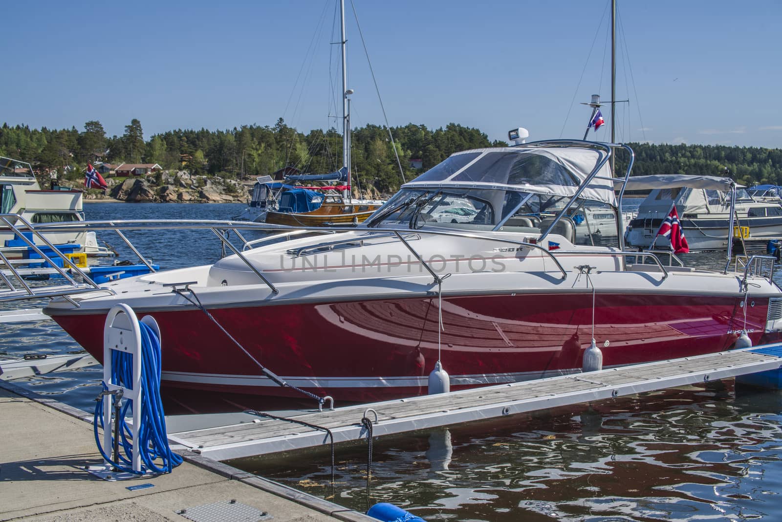 The boat is moored to the dock at the Osco marina in Halden, Norway.