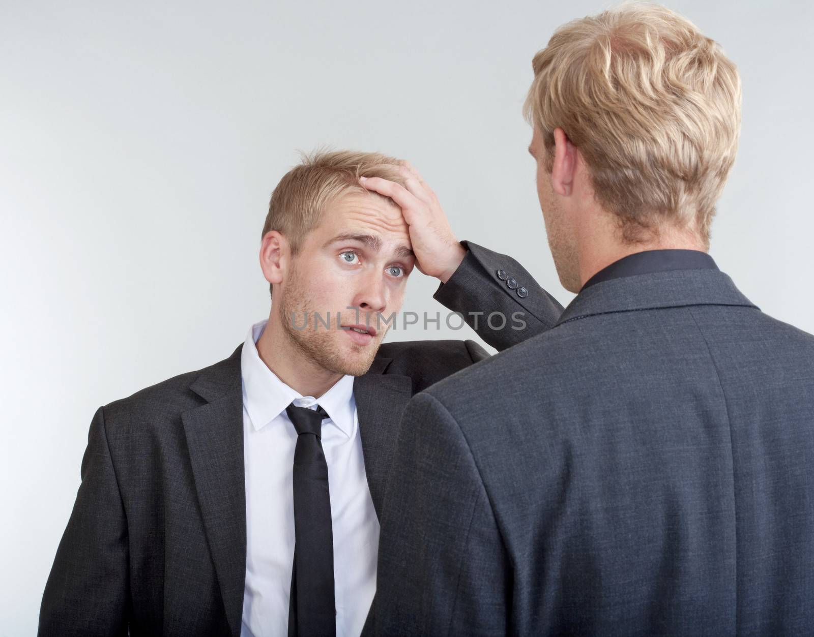 two you businessmen standing, discussing, arguing - isolated on light gray