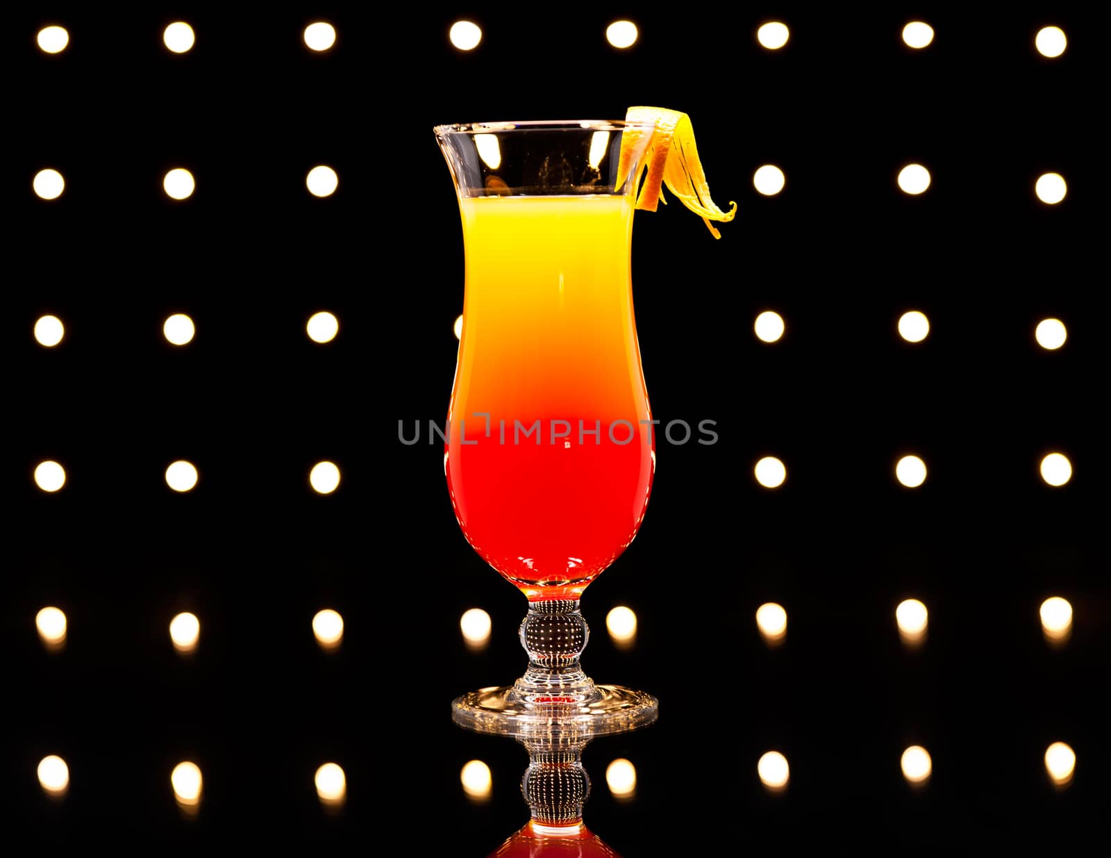 Tequila Sunrise cocktail in front of Disco lights