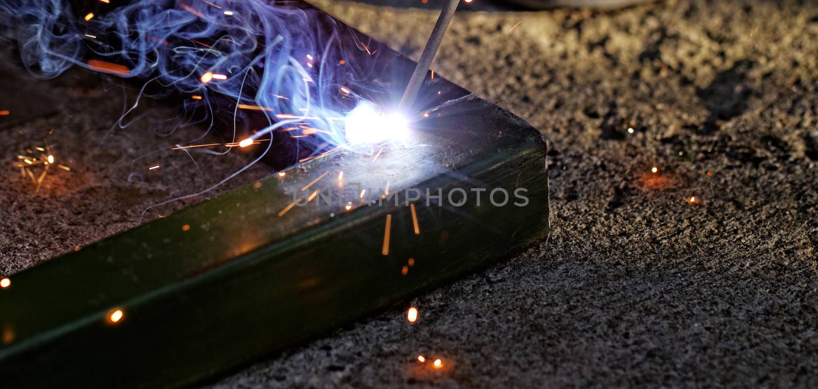 Iron welding with bright light and smoke at manufacturing