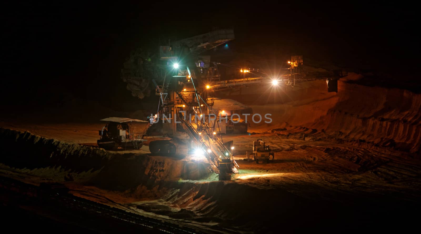 Coal mining in an open pit with huge industrial machine at night shoot