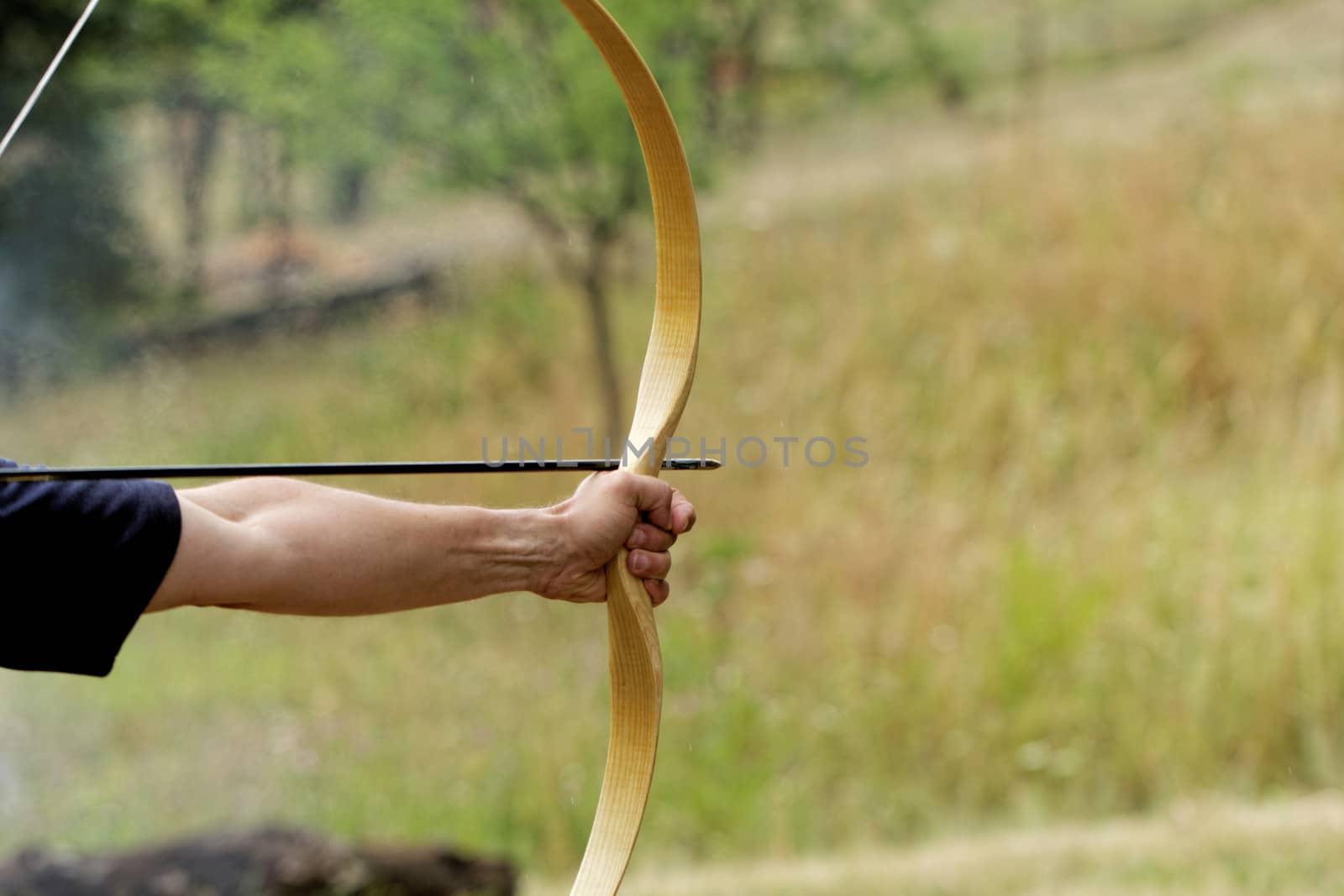 archery man shooting arrow with bow in the nature