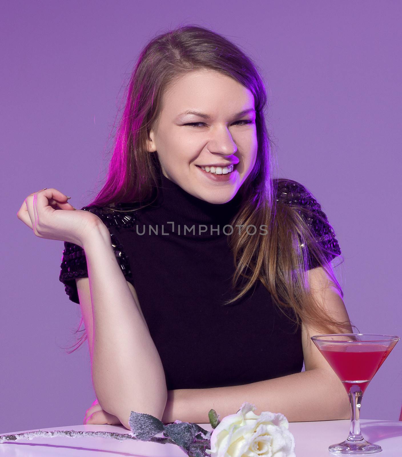 Happy young woman with cocktail at restaurant