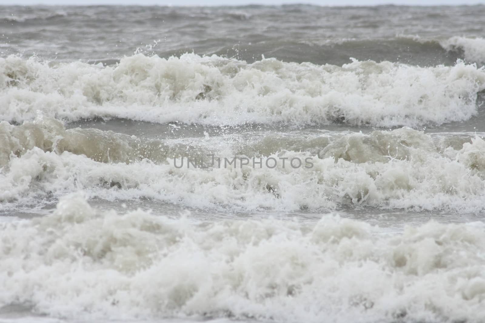 Waves with white crests inundate the sandy beach