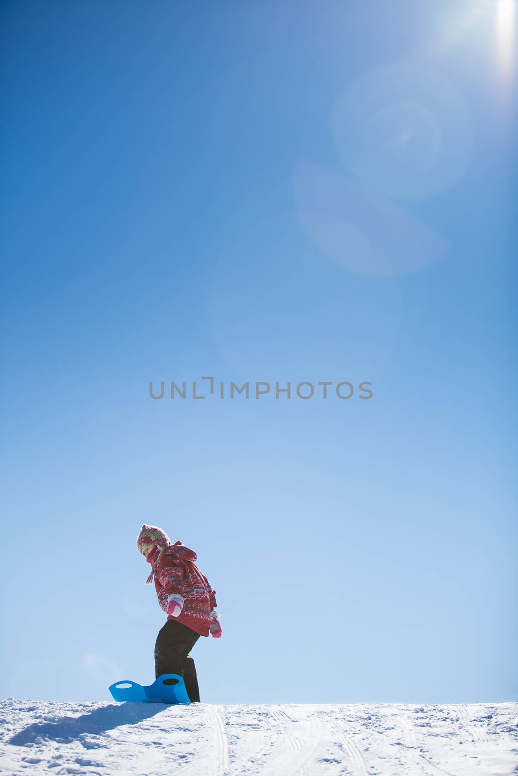 Girl sliding down a hill in the snow