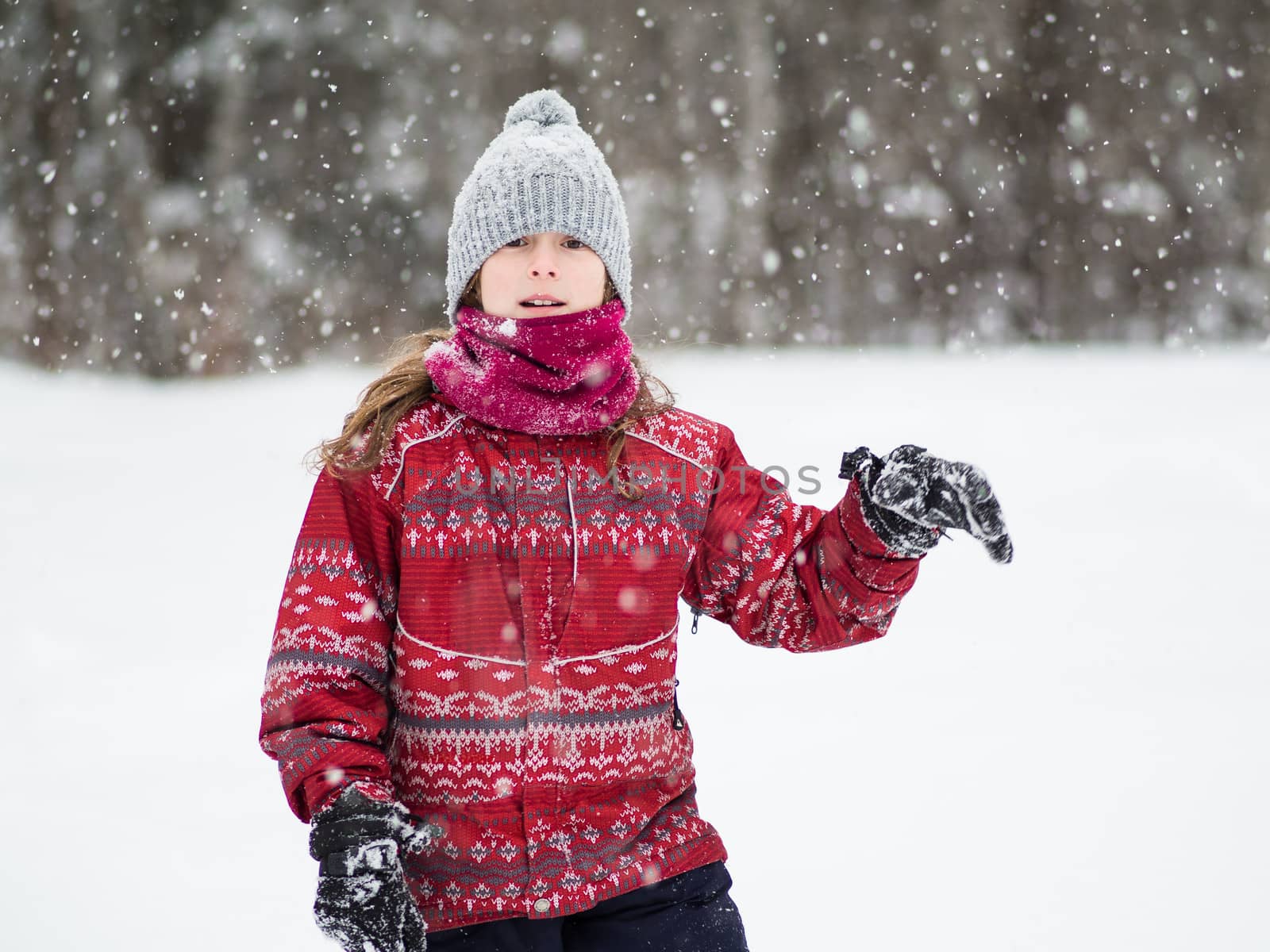 Cute young girl walking in a snow storm