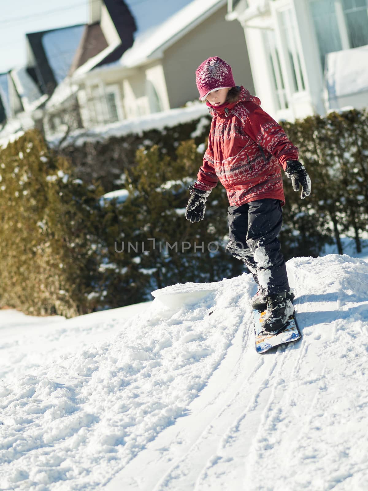 Girl playing in the snow with a snowboard