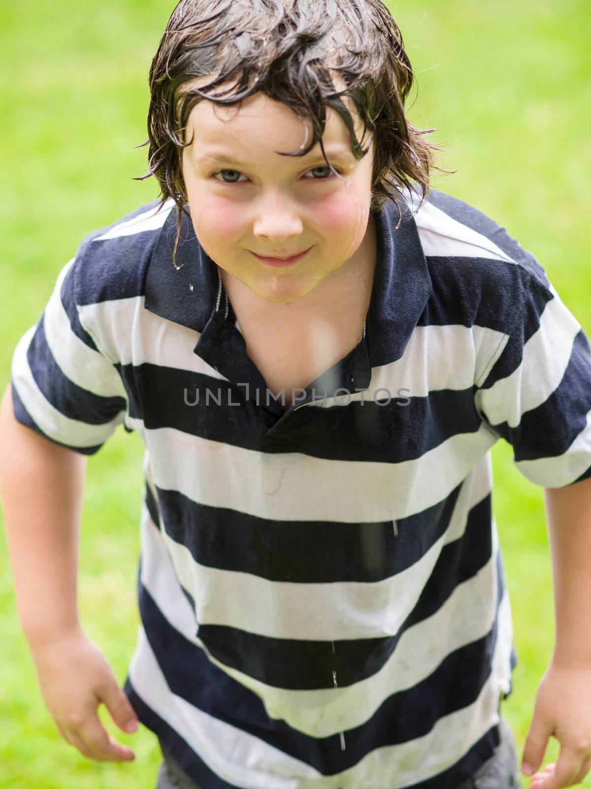 Boy completely wet and playing in the rain