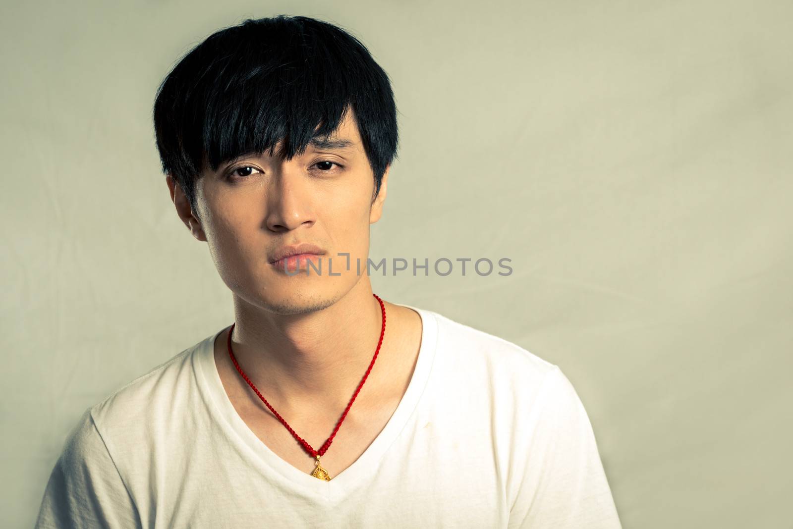 Portrait of young man looking sad and frowning, in fashion tone and background