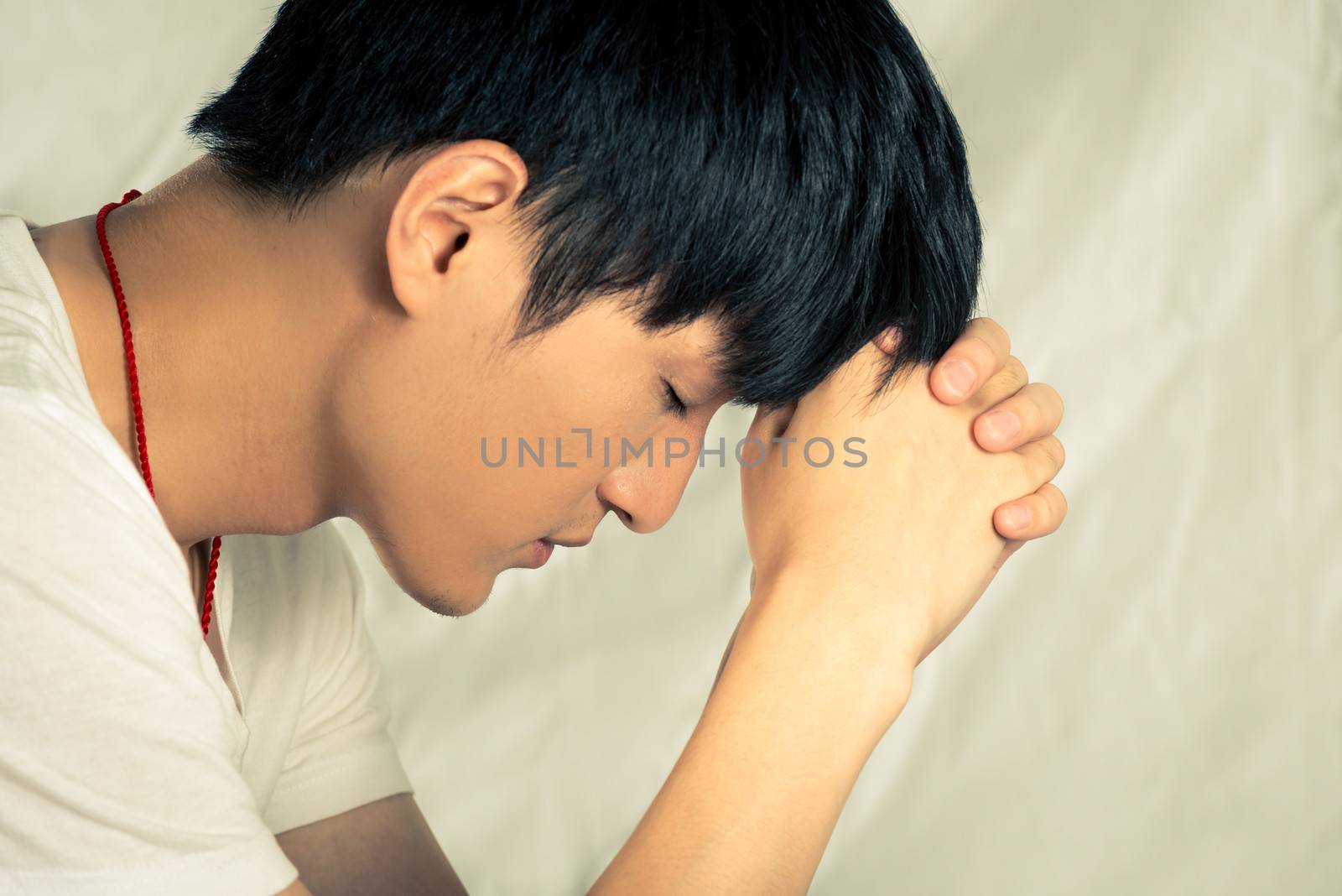 Young man supporting his head looking depressed, in fashion tone and background