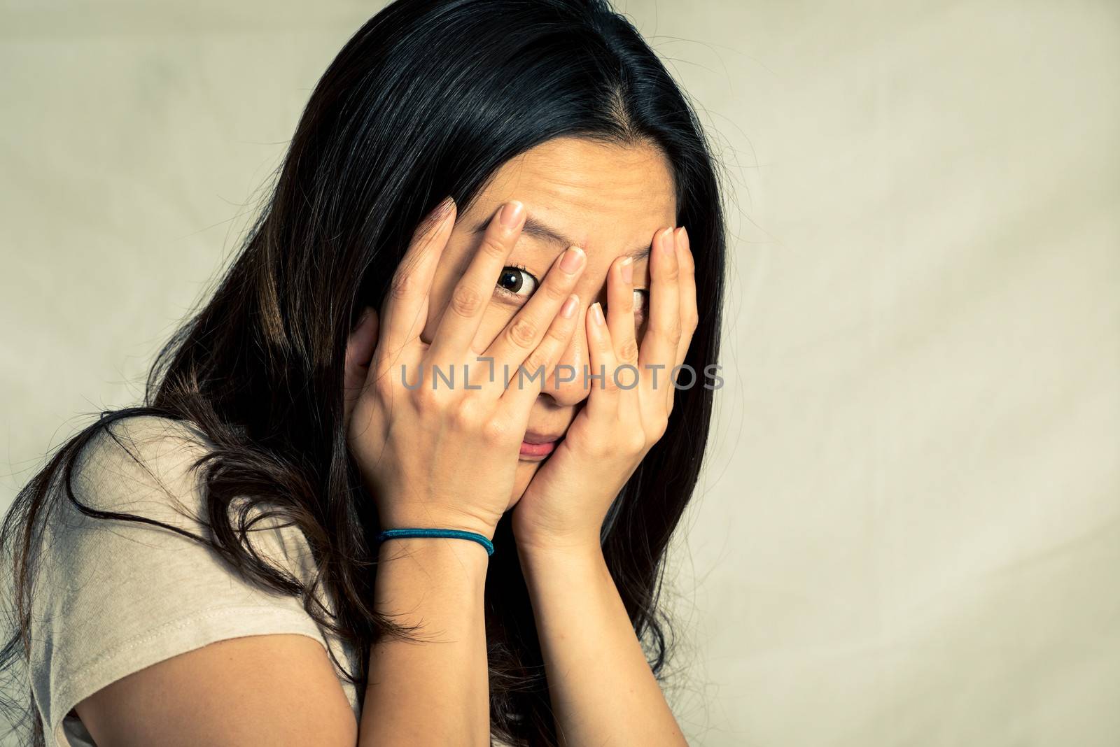 Young woman covering her face, with fashion tone and background