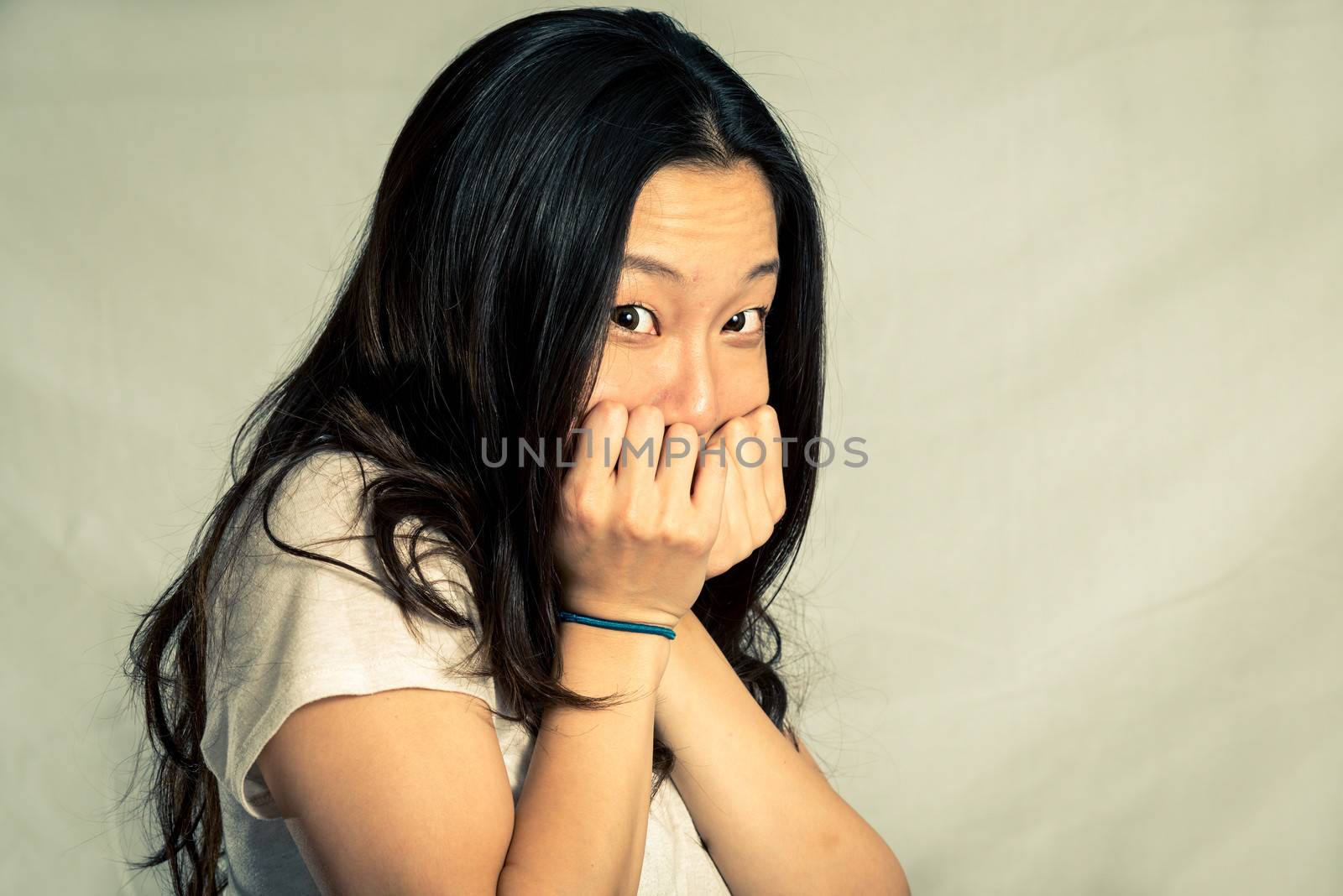 Young woman covering her face, with fashion tone and background