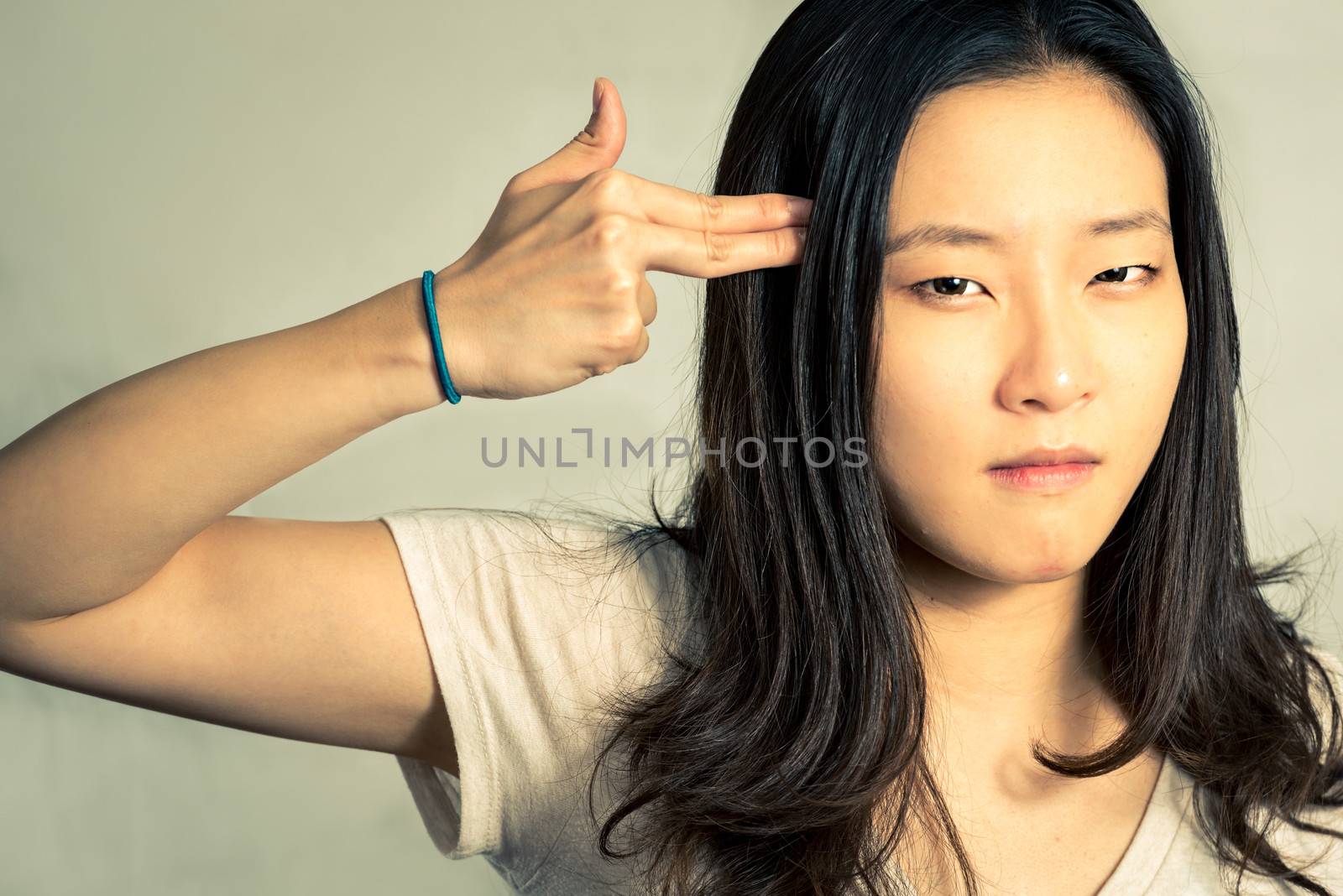 Depressed young woman hand signals suicide, with fashion tone and background