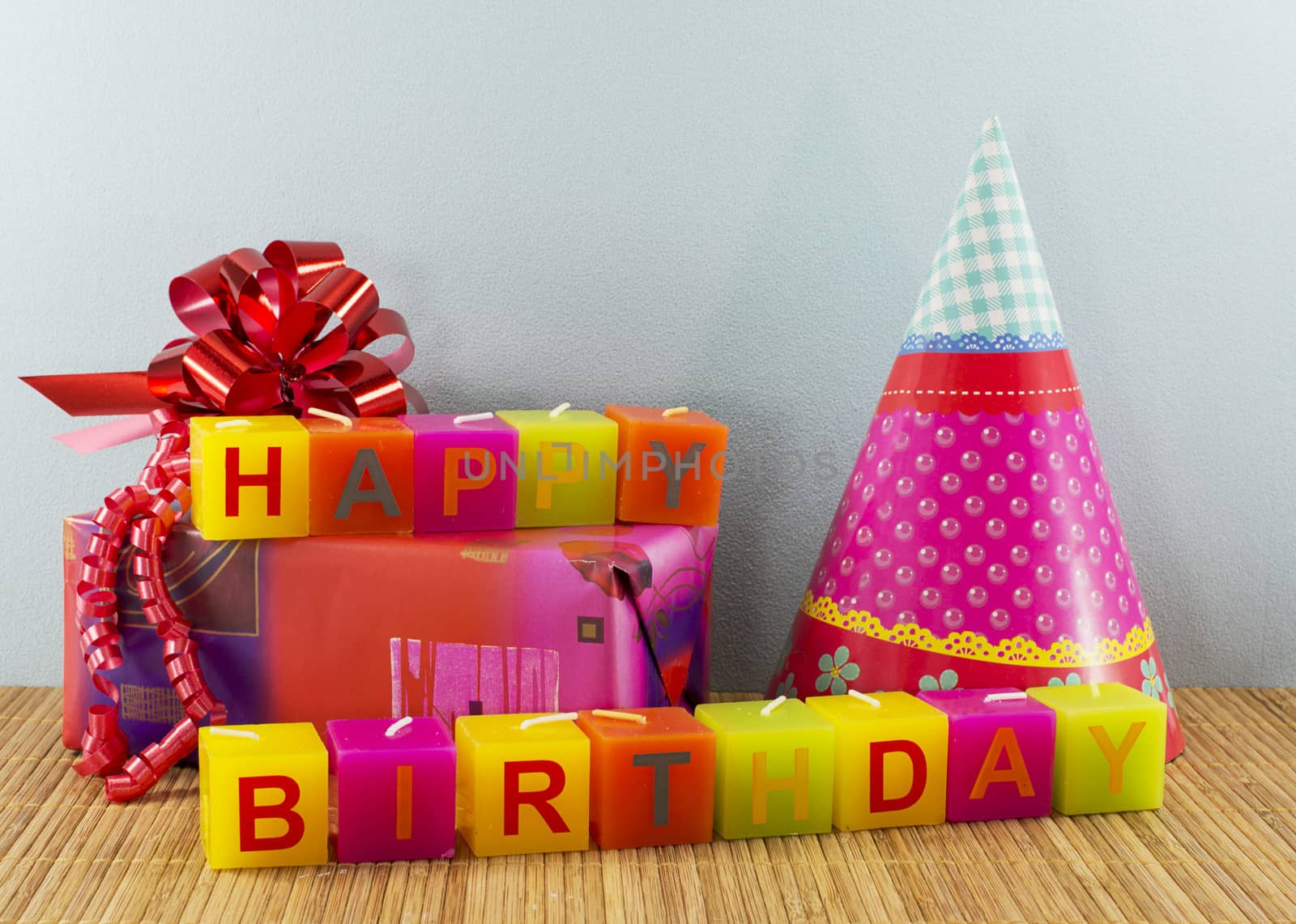happy birthday candles with present and blue wallpaper