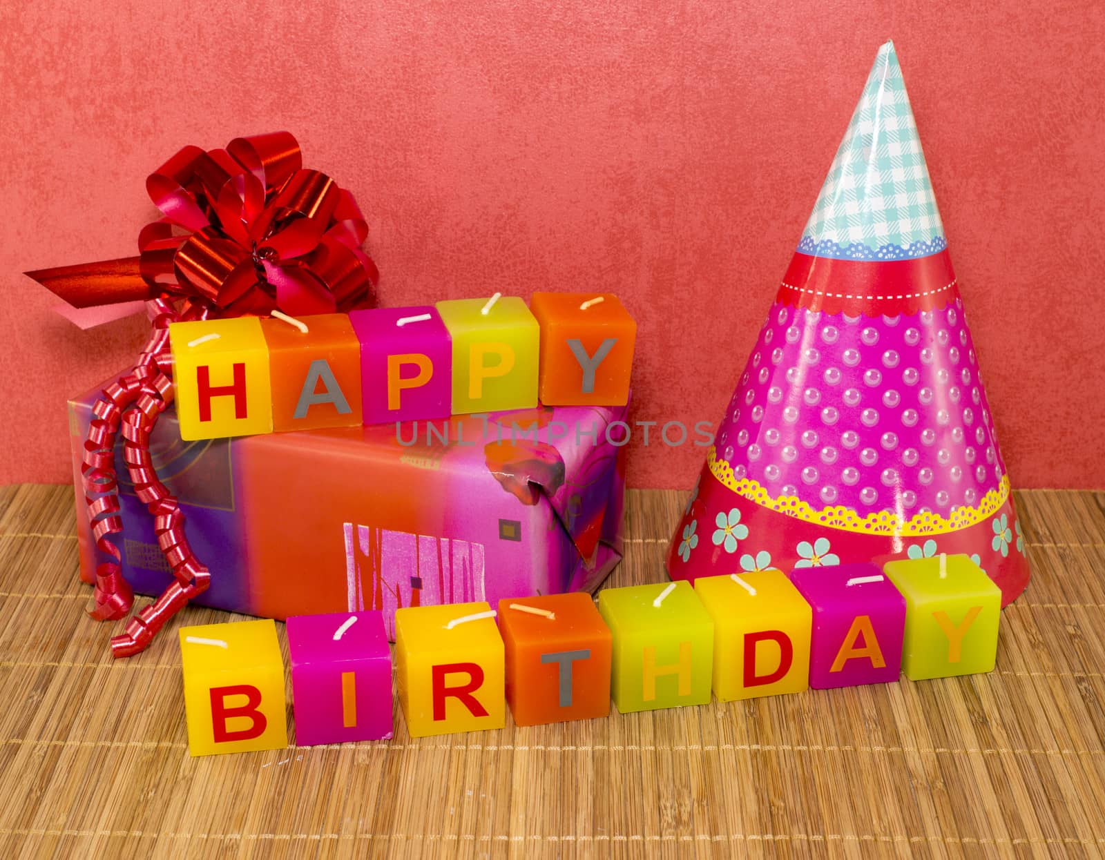 happy birthday candles with present and red wallpaper
