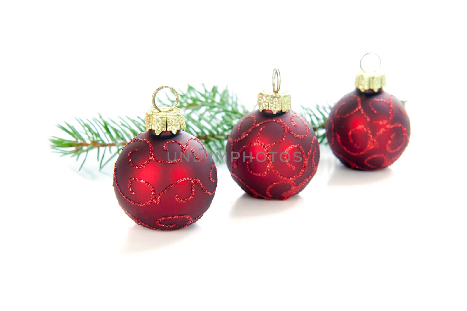 Three christmasballs in a row on a white background