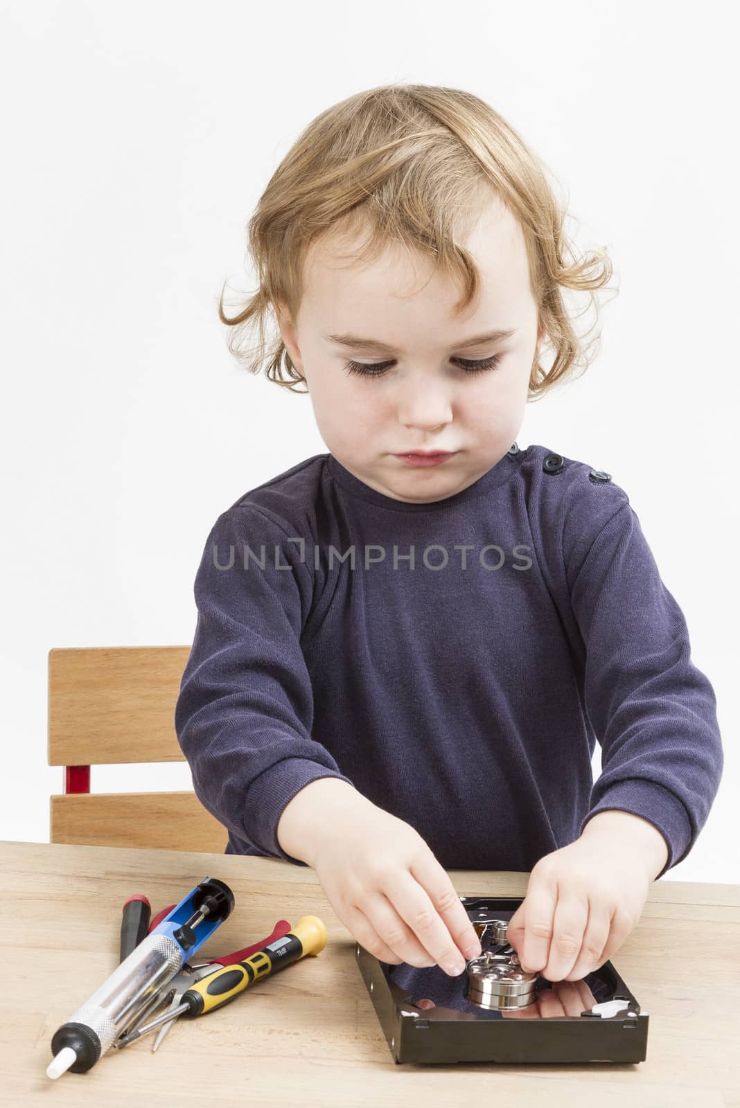 little girl repairing computer parts. studio shot with neutral grey background