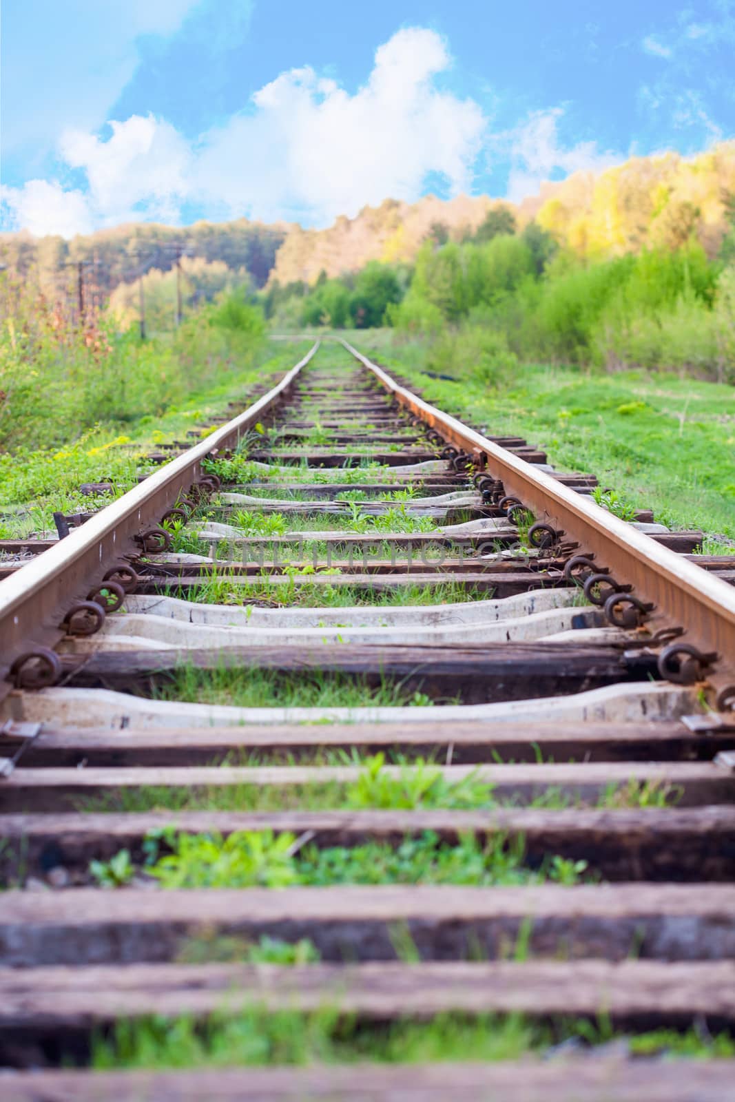 railway tracks in a rural scene with nice blue sky by sfinks