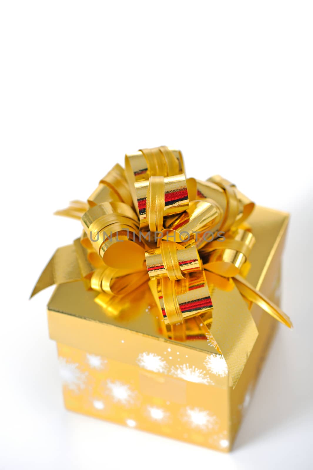 Golden gift box with golden ribbon on white background