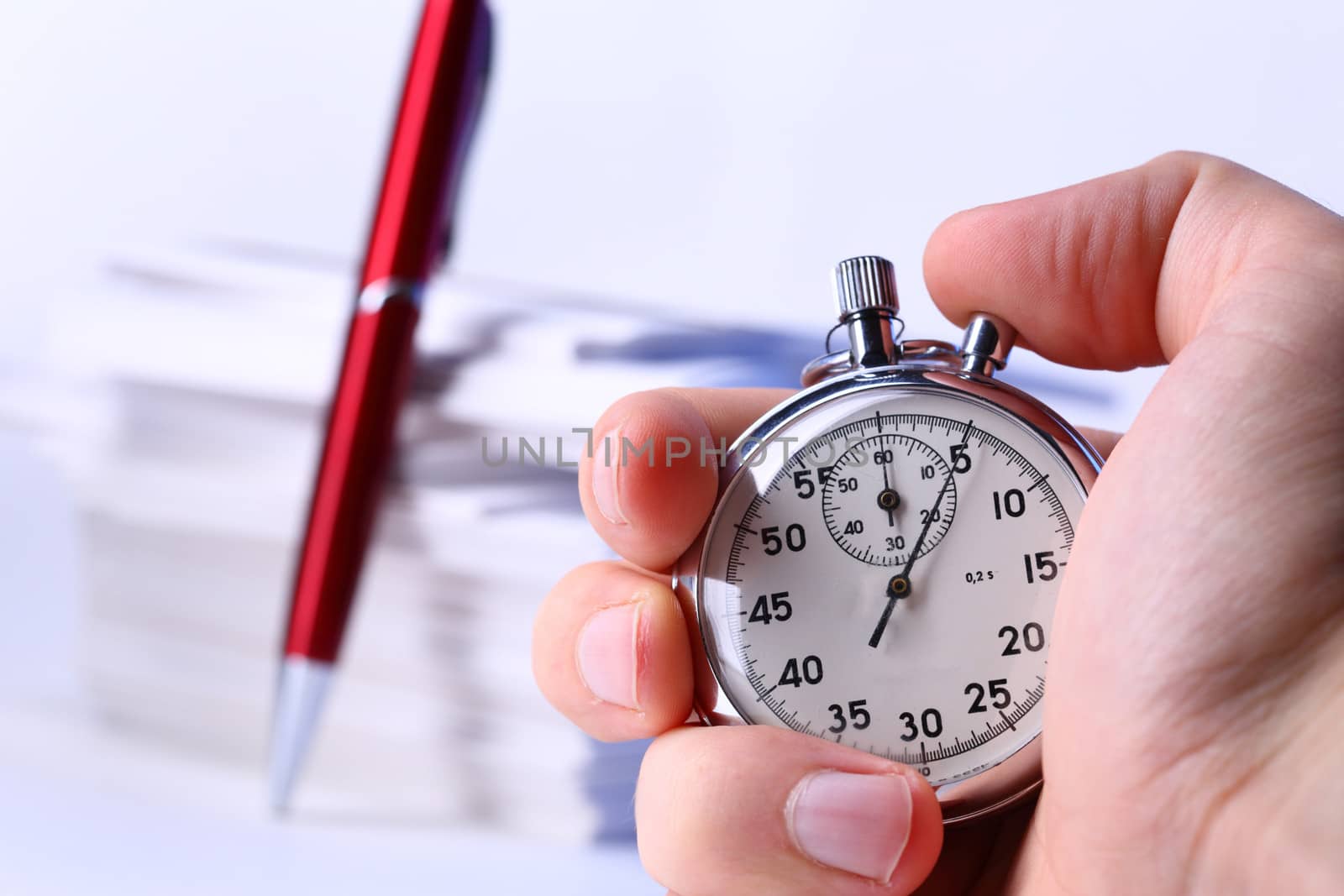 Stopwatch in hand on background of paper cards