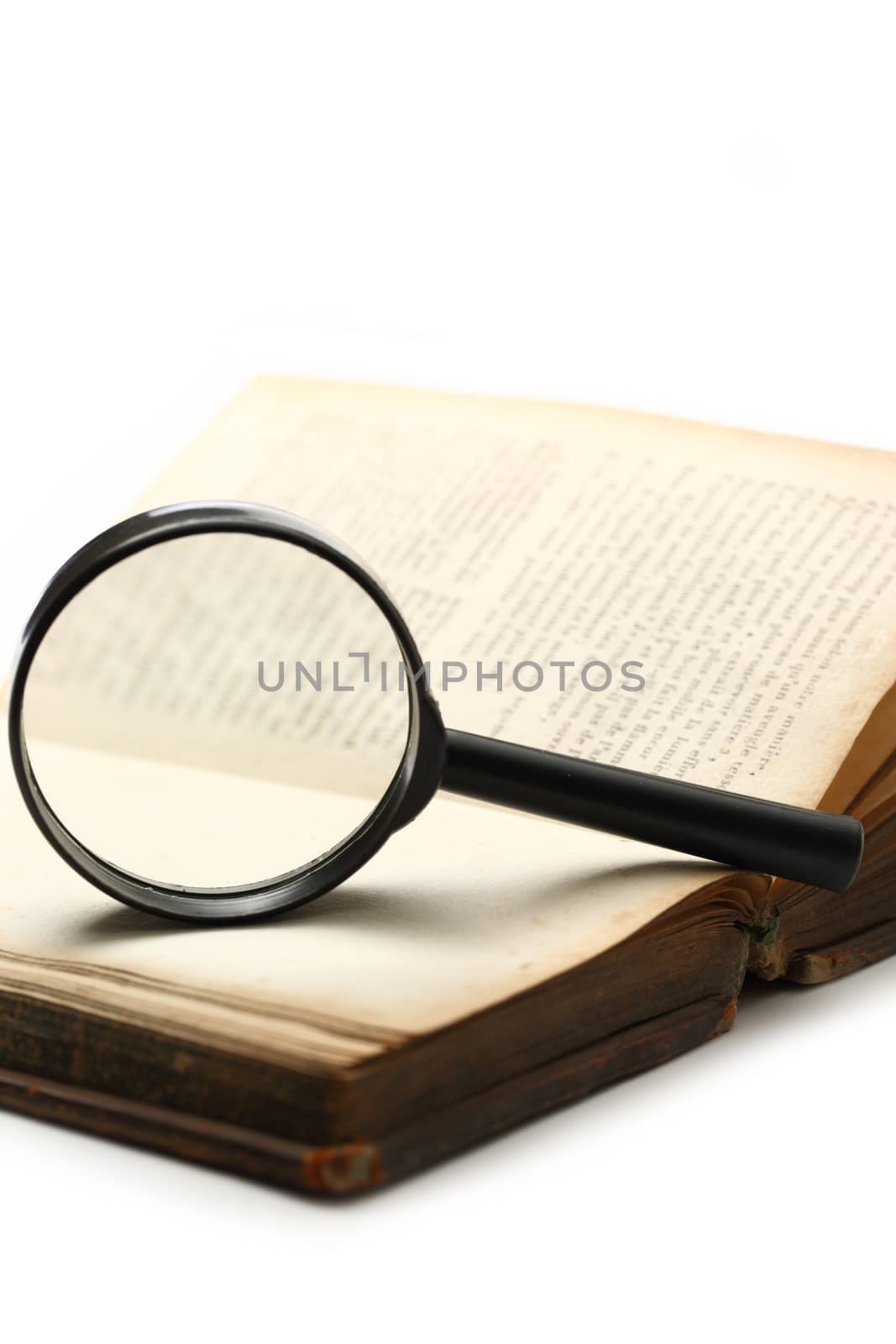 Magnifying glass and old book on the white background