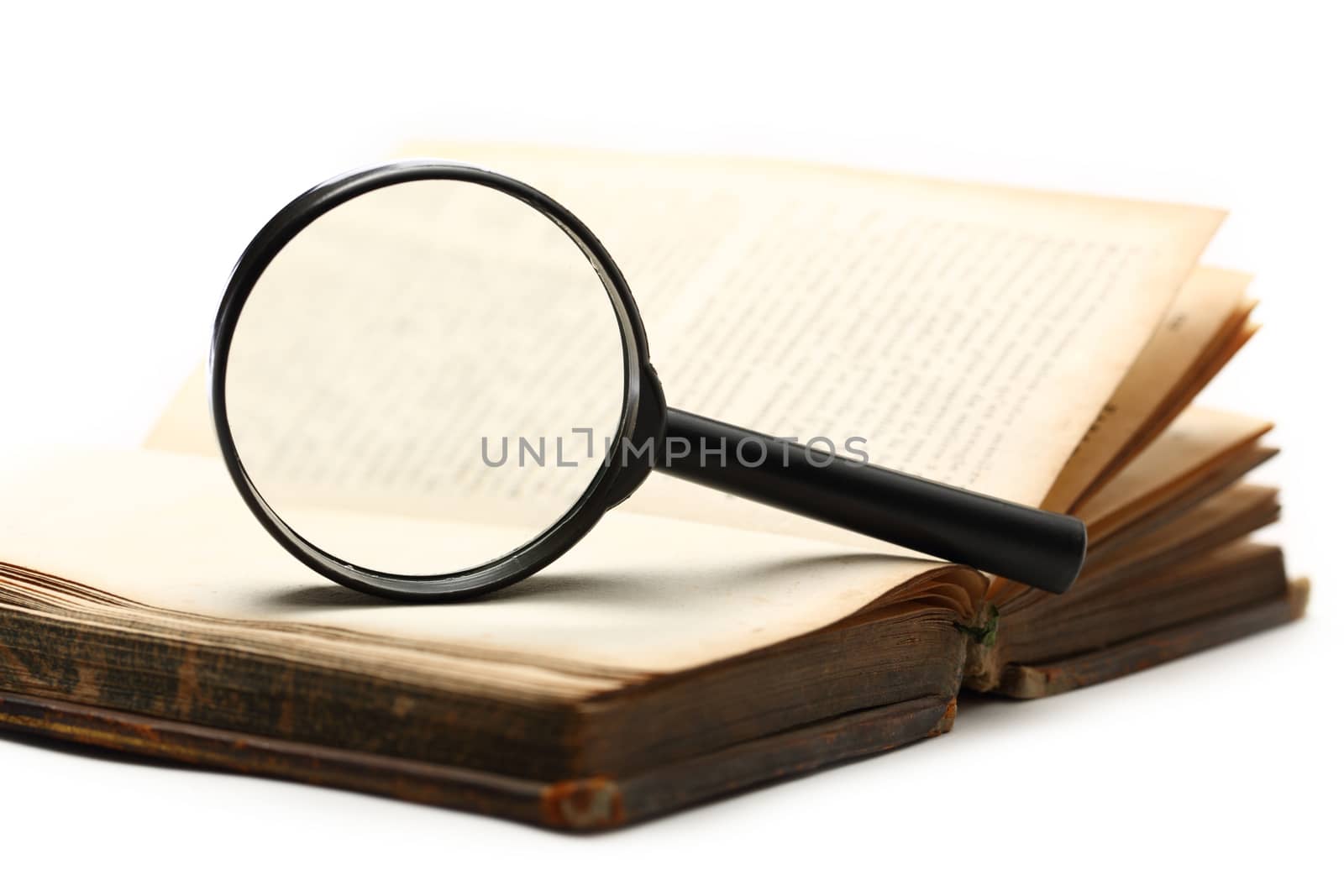 Magnifying glass and old book on the white background