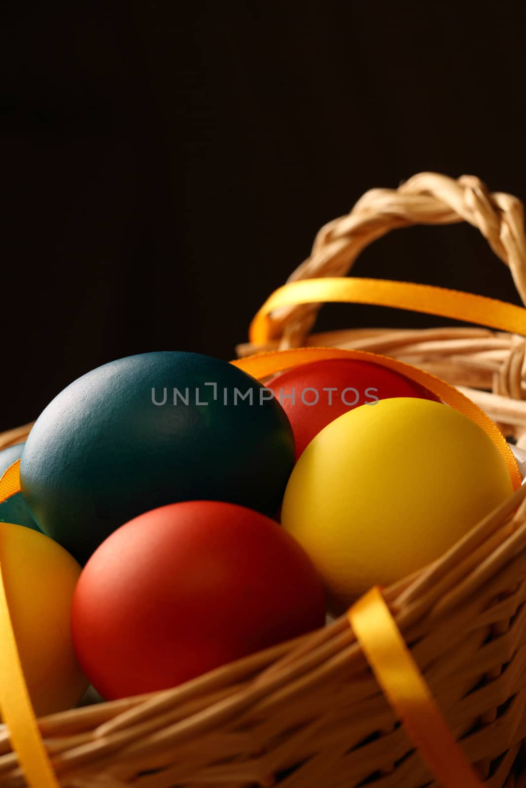 Easter eggs with yellow ribbon in basket by Garsya