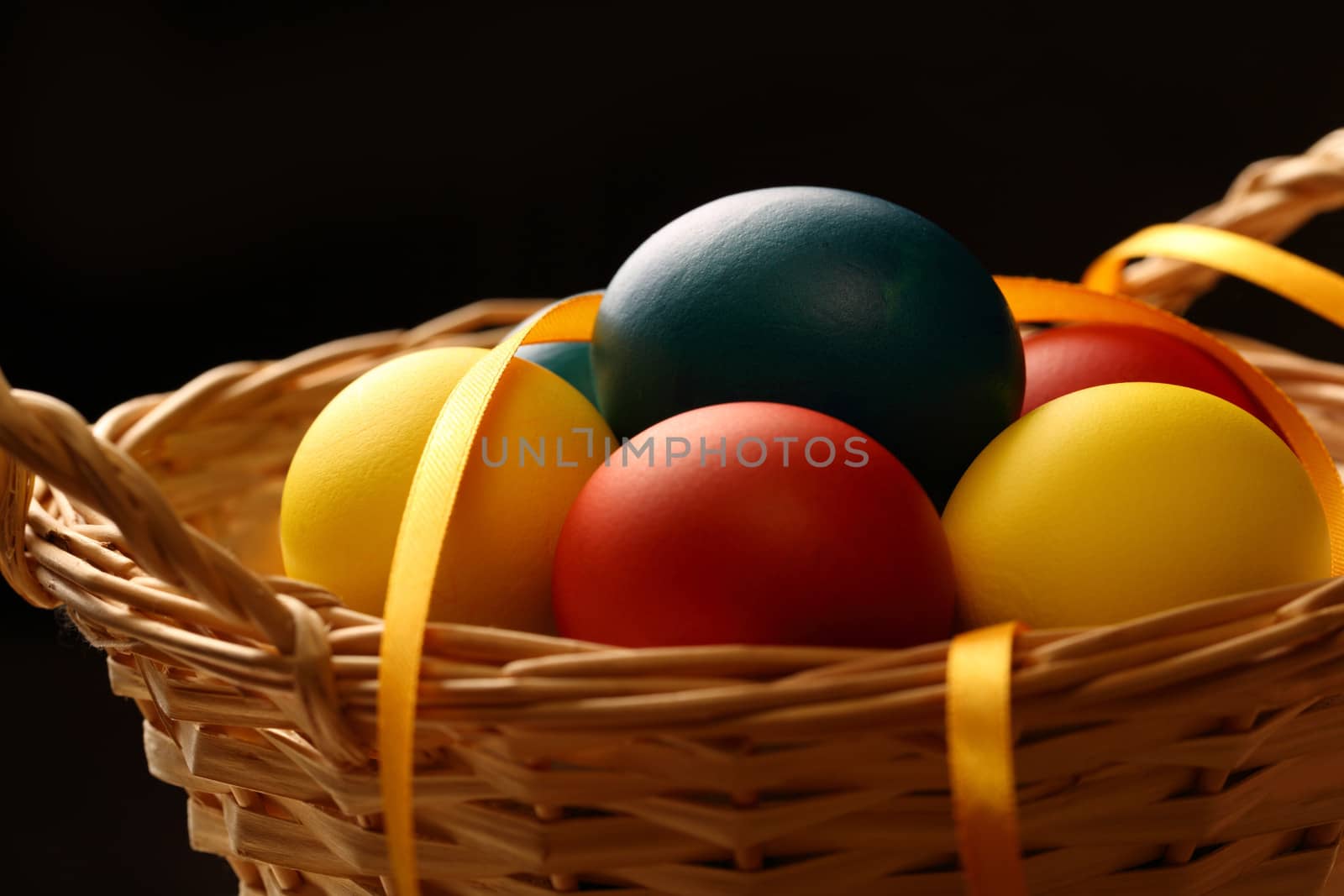 Easter eggs with yellow ribbon in basket