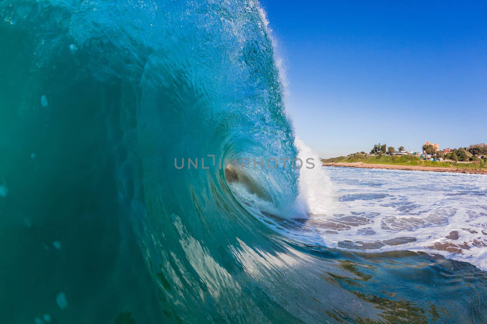 Water angle of hollow ocean wave breaking onto shallow sandbar.