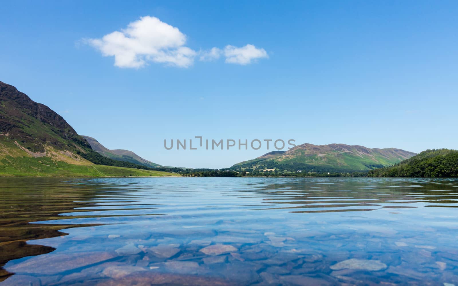 Mirror like reflection of the Lake District hills surrounding Crummock with a very low viewpoint emphasizing the water. Idyllic image from the English Lakes