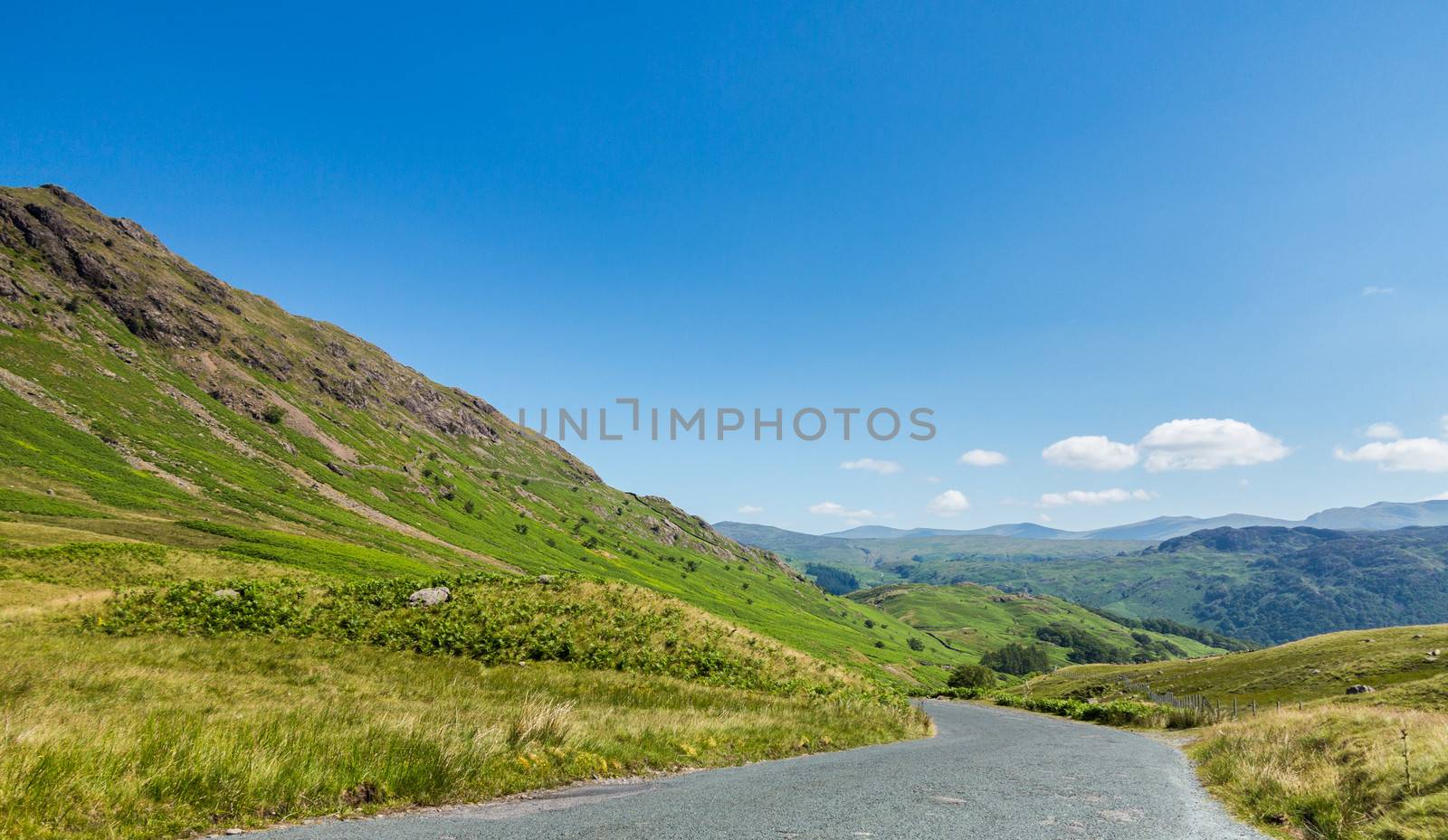 Narrow road leads down from Honister Pass in the English Lakes or Lakeland Lake District in Cumbria