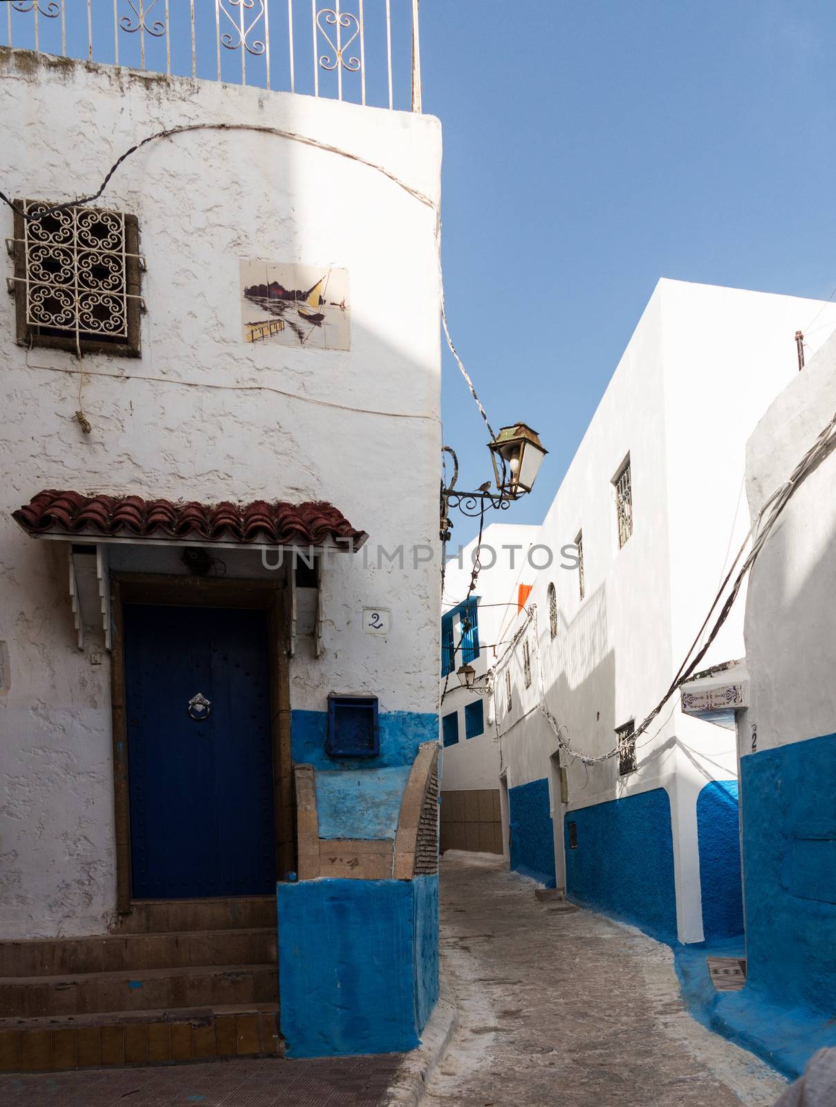 Narrow street or path in the Medina or old town of Rabat in Morocco with blue and white painted homes