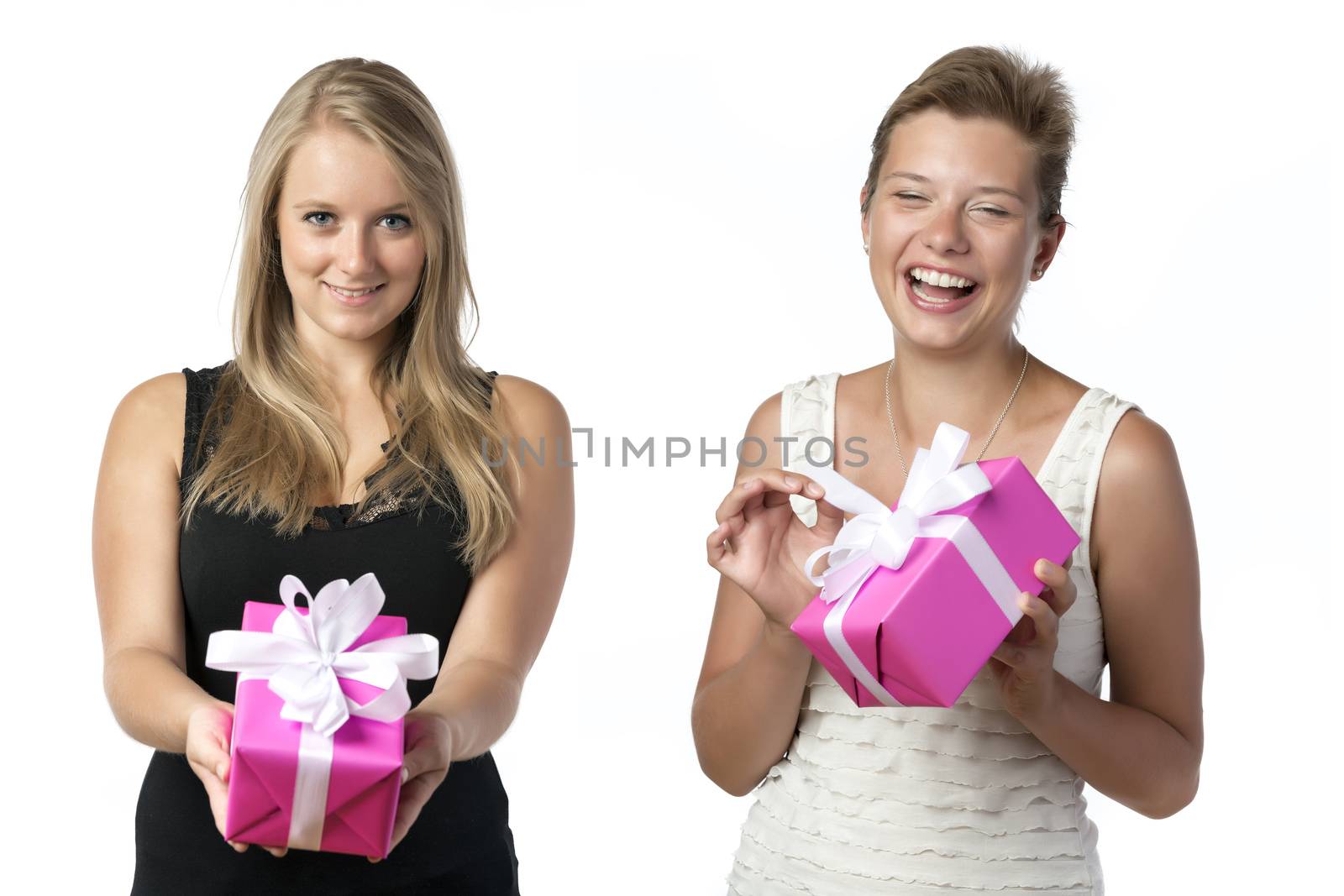 Two happy women, a blond with black top and a brunette with white top, holding a christmas or brithday present, isolated on white background