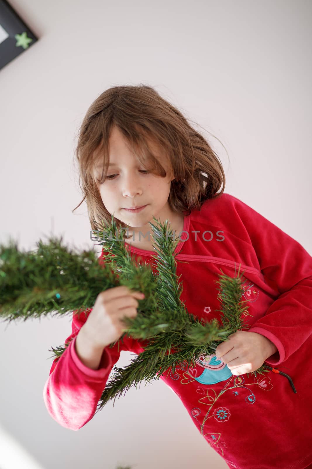 Girl decorating a Christmas tree by Talanis