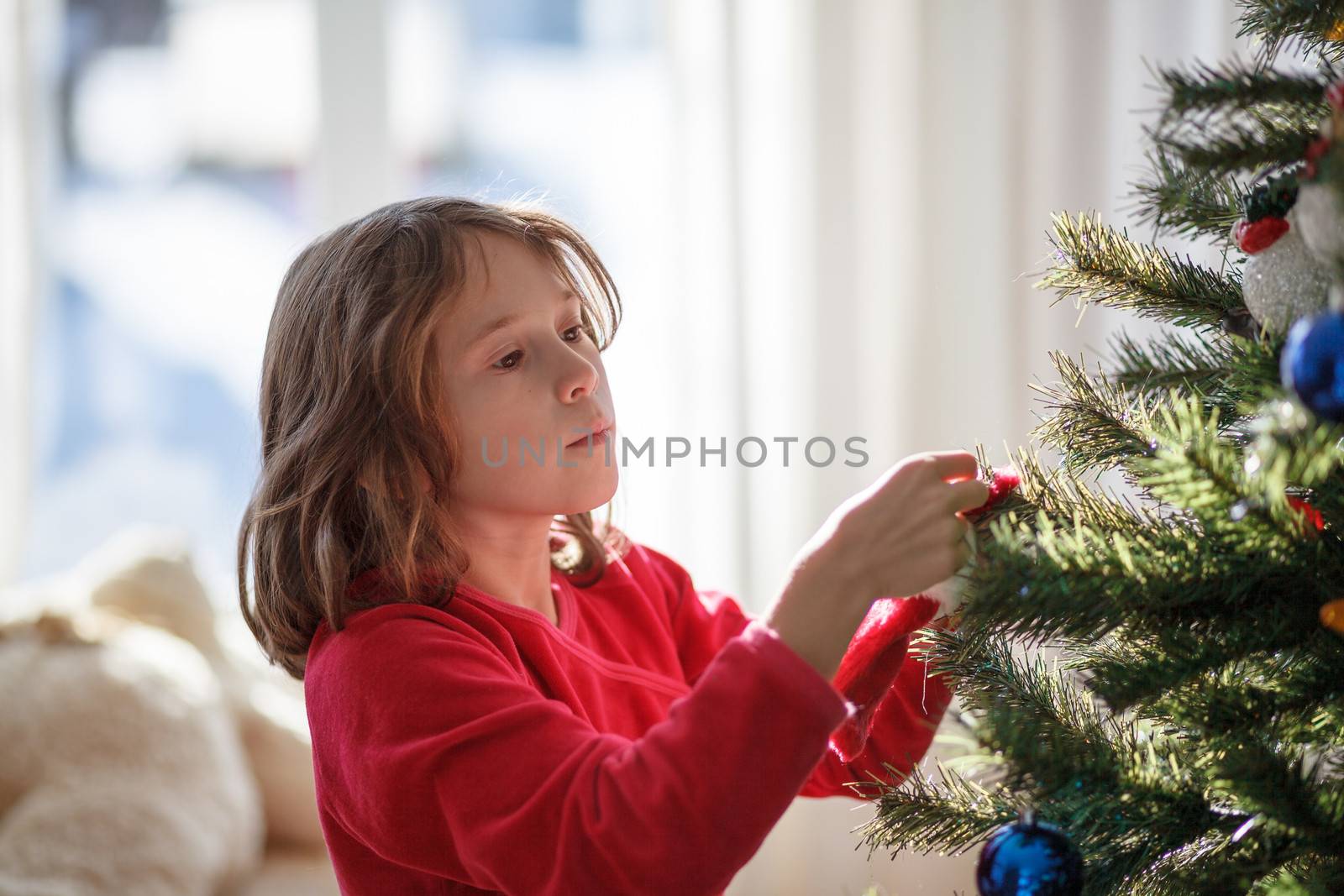 Girl decorating a Christmas tree by Talanis