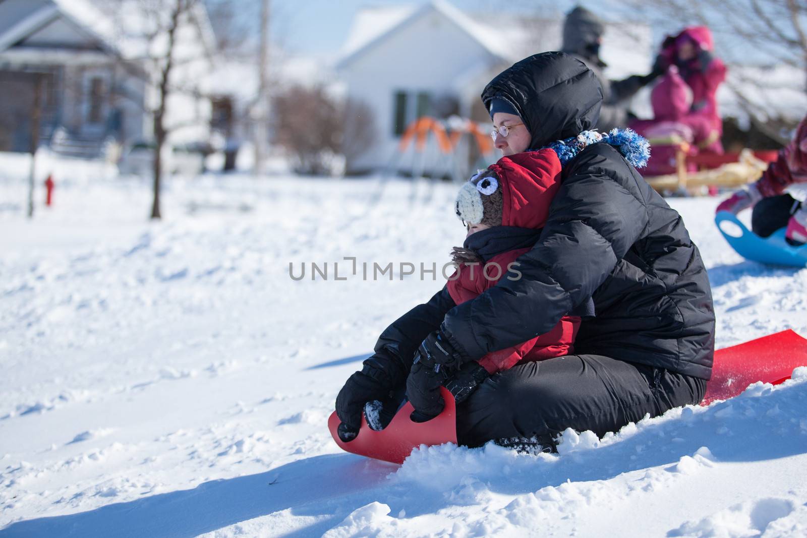 Mother and son sliding on a carpet down a hill