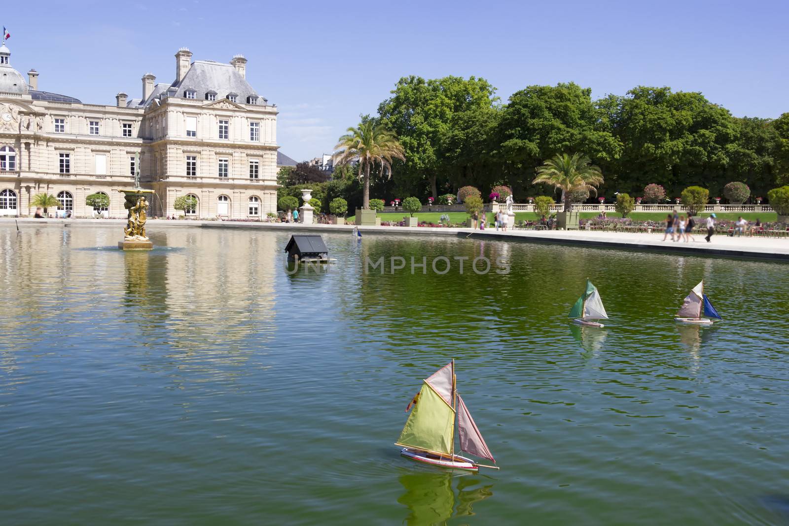 Traditional small wooden sailing boat in the pond of park Jardin by Tetyana