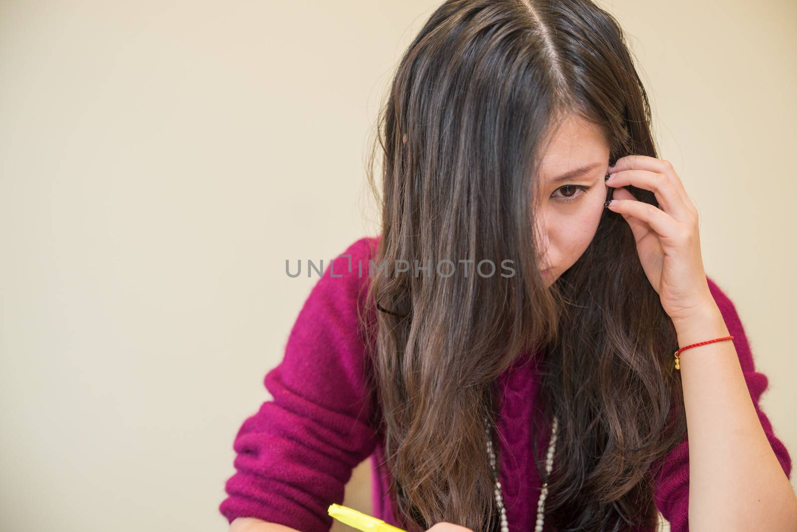 Woman studying with pen in hand looking angry