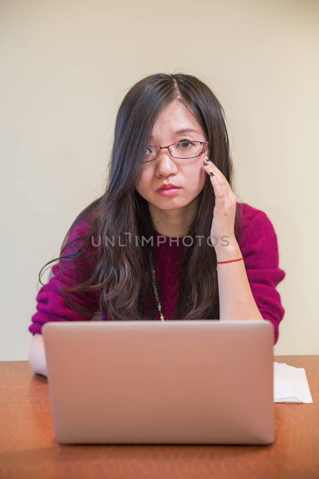 Portrait of young woman with glasses, book and laptop