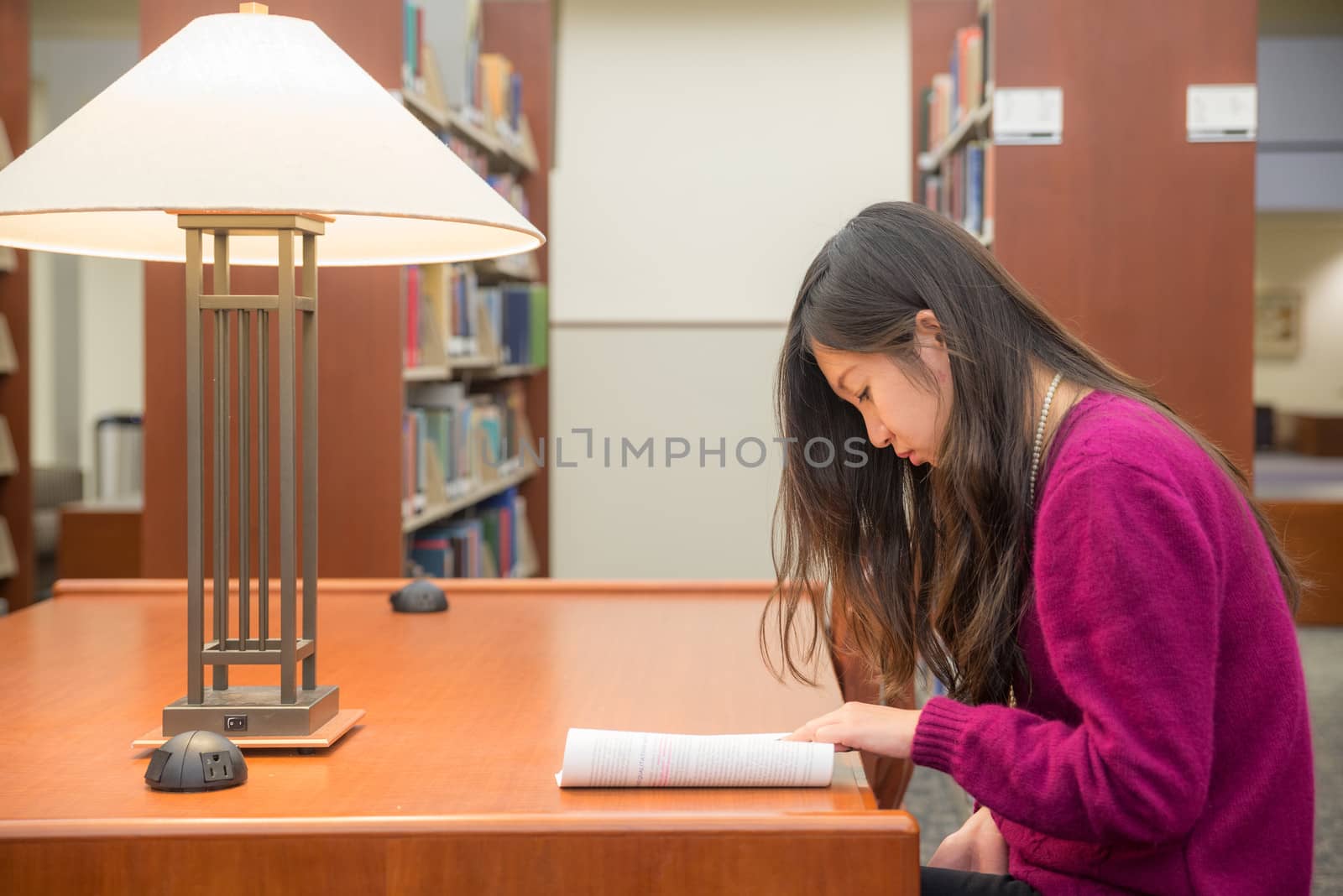 Woman with book studying in library