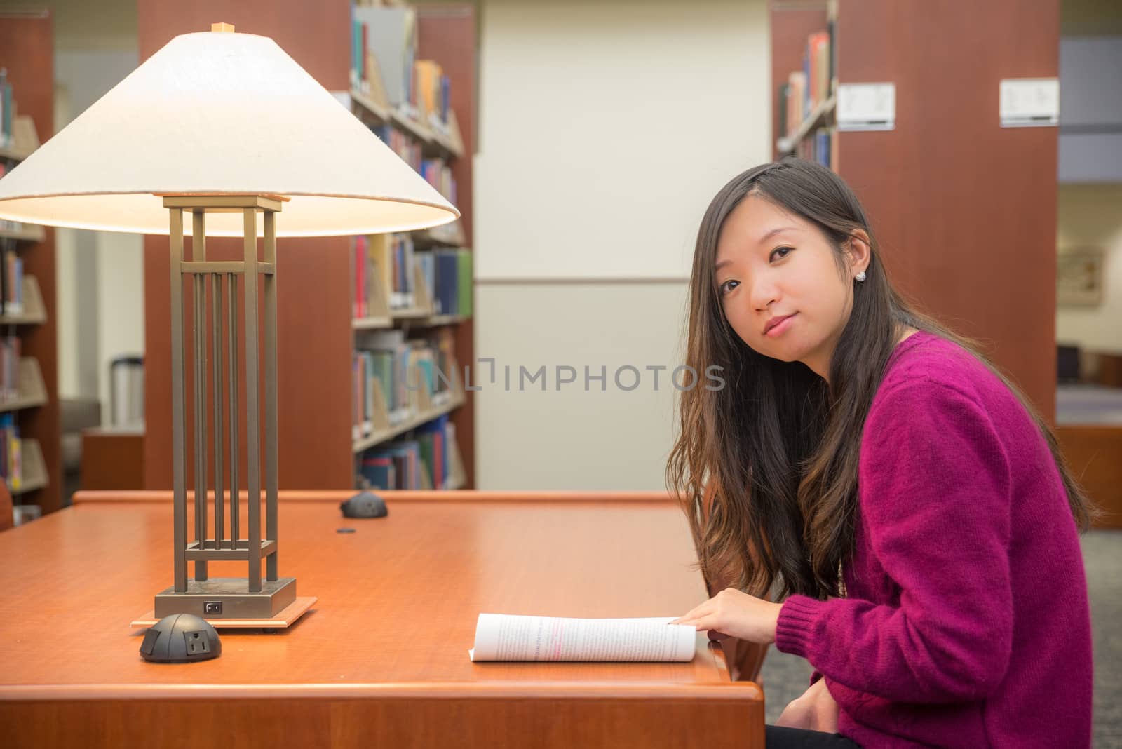 Woman with book studying in library