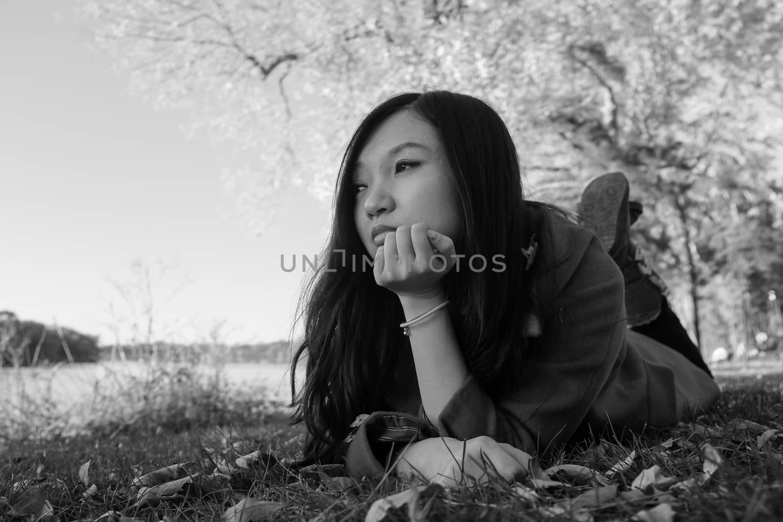 Woman laying on grass looking happy