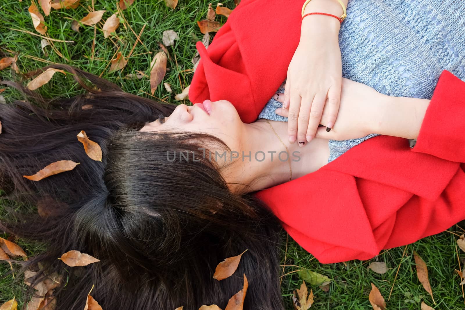 Young woman laying on grass with spreaded hair