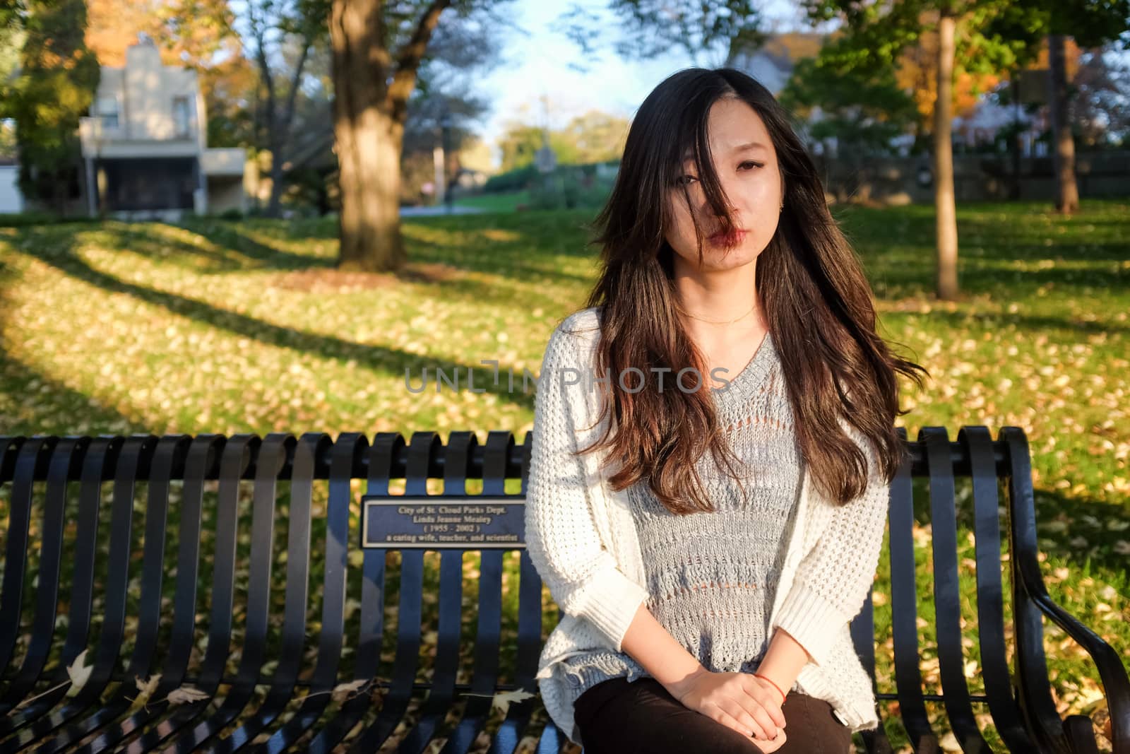 lonely young woman sitting on a steel bench