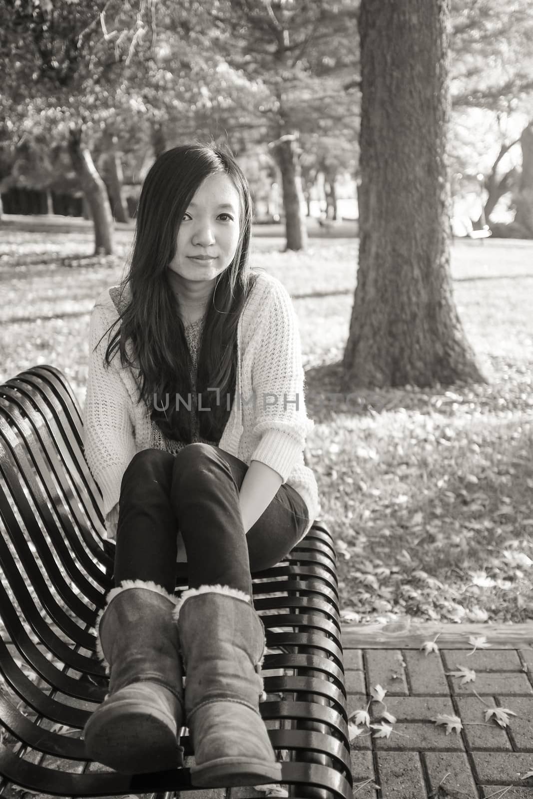 Woman sitting on bench by IVYPHOTOS