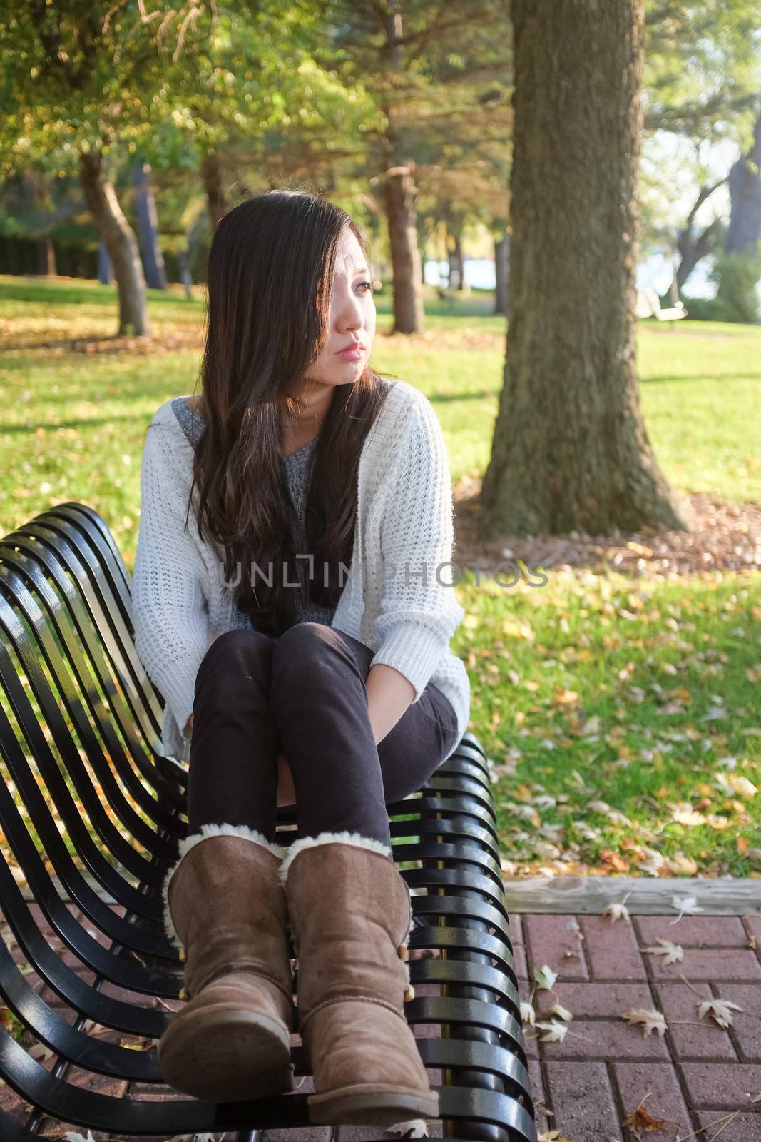 lonely young woman sitting on a steel bench